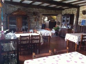 a dining room with tables and chairs and a stone wall at Casa das Augas Santas in Aguas Santas