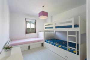 1 dormitorio con 2 literas y ventana en Housingcoruña Apartamento Playa Miño 03 en Miño