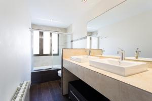 a bathroom with two sinks and a large mirror at Housingcoruña Apartamento Playa Miño 03 in Miño