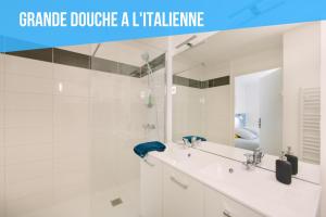 a white bathroom with a sink and a mirror at Appartistic - Appartement des artistes in Nantes +17 photos