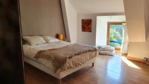 un dormitorio con una cama y una ventana en Les Floralis, en La Grée-Saint-Laurent