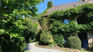 an ivy covered house with a walkway in front of it at Les Floralis in La Grée-Saint-Laurent