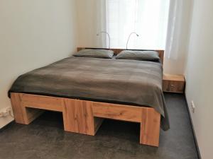 a bed in a bedroom with a wooden bed frame at FEWO am Neuen Dom in Linz