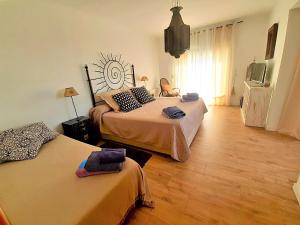 ein Schlafzimmer mit zwei Betten und einem Fernseher in der Unterkunft Villa Mur - Espectacular villa cerca de Sitges y BCN in Olivella + 54 Fotos