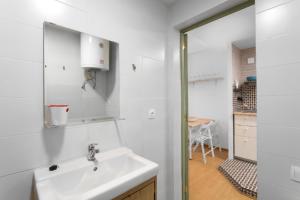 a white bathroom with a sink and a mirror at Flat near the beach and center of Tossa de Mar "Sol" in Tossa de Mar +10 photos