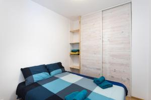 a small bedroom with a blue and white bed at Flat near the beach and center of Tossa de Mar "Sol" in Tossa de Mar