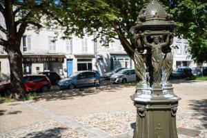 Eine Stange mit einer Statue an der Seite einer Straße. in der Unterkunft Appartement T3 classé***centre ville in Périgueux