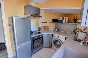 eine Küche mit einem Kühlschrank und einer Waschmaschine in der Unterkunft Appartement T3 classé***centre ville in Périgueux