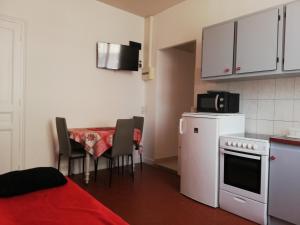a small kitchen with a table and a microwave at Appartement Le Cernuschi 2C in Menton