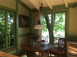 a dining room with a table and some windows at Baumhaus auf dem Kellerberg in Fischach