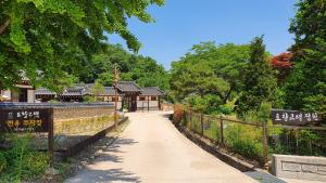 a walkway in a park with a building at Tohyang Traditional House in Bonghwa