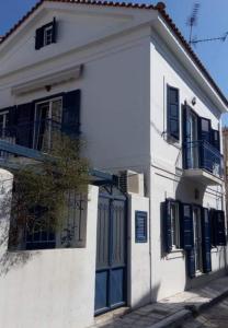 een wit huis met blauwe deuren en ramen bij Samia Seavilla Pythagorio in Pythagoreio