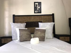 a bedroom with a bed with white sheets and pillows at Kaste Guesthouse Secunda in Secunda