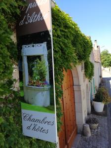 a sign for a house with a plant in a pot at Chambres et Tables d'hôtes du Puits d'Athie in Appoigny