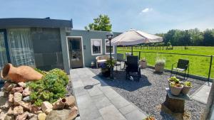 a patio with an umbrella and some plants at HOME for 2 in Zuidoostbeemster