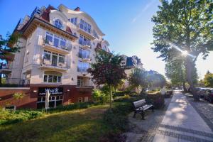 a building with a park bench in front of it at Apartamenty na Wyspie - Promenada in Świnoujście