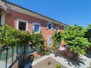 an empty courtyard of a building with a tree at Le temps des pauses in Viviers