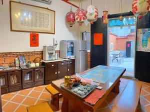 a kitchen with a table and a refrigerator at 嚨口秘境古厝民宿Longkou Mysterious Resort in Jinning