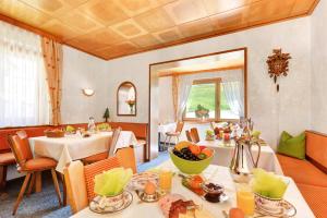 ein Esszimmer mit zwei Tischen mit Essen drauf in der Unterkunft Haus Bergwiese in Baiersbronn