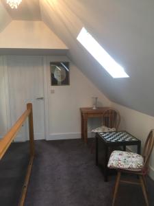 a attic room with a skylight and a table and chairs at Folly Fields Farm B&B in Sherborne