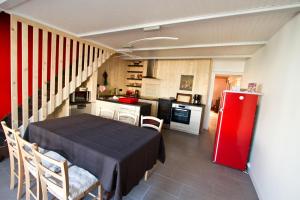una pequeña cocina con mesa y nevera roja en Au grain de Celles, en Celles-en-Bassigny