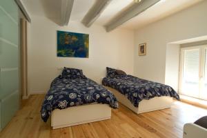 1 dormitorio con 2 camas y ventana en Au grain de Celles, en Celles-en-Bassigny