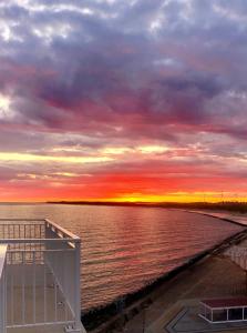 uma vista para o oceano ao pôr-do-sol a partir de um navio de cruzeiro em Apartamenty w Marina Royale em Darlowko