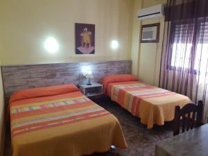 A bed or beds in a room at Hostal Virgen Del Rocío