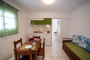 a kitchen and a living room with a table and a couch at Sunny Garden in Nydri