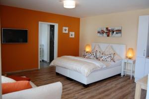 a bedroom with a bed with an orange wall at Apart Hotel - Dillinger Schwabennest in Dillingen an der Donau