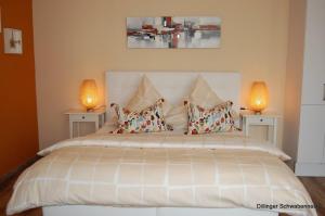 1 dormitorio con 1 cama blanca grande y 2 lámparas en Apart Hotel - Dillinger Schwabennest, en Dilinga