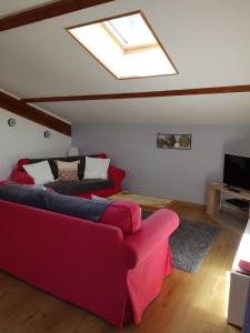 a living room with a red couch and a skylight at Les Trois Lions in Foix