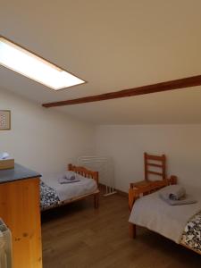 Habitación con 2 camas y 2 sillas en Les Trois Lions, en Foix