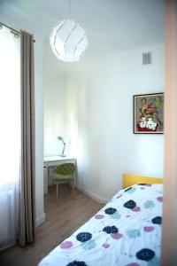 1 dormitorio con cama, escritorio y lámpara en Stylowy Apartament w Kamienicy, en Chełm