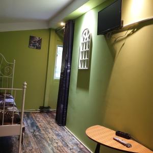 a bedroom with green walls and a bed and a table at Old Centrum Bucharest in Bucharest