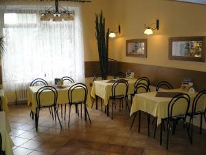 a dining room with tables and chairs with yellow table cloth at Pension Duel in Ústí nad Labem