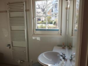 ein weißes Bad mit einem Waschbecken und einem Fenster in der Unterkunft Marinapark Scharmützelsee in Wendisch Rietz