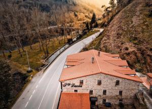 a building with an orange roof next to a road at Apartamentos Santa Lucia in Cabezón de la Sal