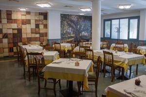 une salle à manger avec des tables et des chaises ainsi qu'une peinture murale. dans l'établissement Hostal La Palmera, à Miajadas