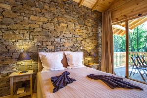 Un dormitorio con una cama con una pared de piedra. en Garmen Hills Guest Houses, en Garmen 149 fotos más
