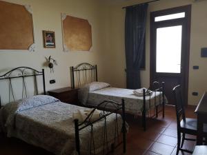 Pokój z 3 łóżkami, oknem i drzwiami w obiekcie Agriturismo Catena w mieście Cirò