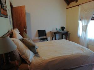 sypialnia z dużym białym łóżkiem i oknem w obiekcie A Swallows Rest w mieście Kareedouw