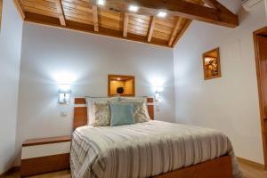 a bedroom with a bed and two lights on the ceiling at Casa Largo S Lourenço e Casa da Videira in Mazes