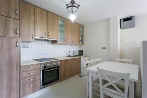 a kitchen with wooden cabinets and a table with chairs at Housingcoruña Apartamento Playa Miño 01 in Miño +8 photos