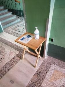 a small table with a bottle on it next to a staircase at Residenza d'Epoca Palazzo Riblet in Florence