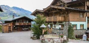 Cette grande maison en bois dispose d'un balcon dans une rue. dans l'établissement Hotel Silbertal - Almhütten, à Sölden