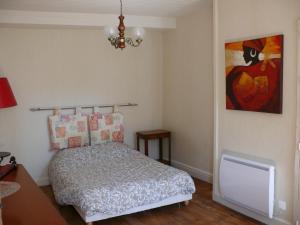 een slaapkamer met een bed en een schilderij aan de muur bij La mémée du Saillant in Voutezac