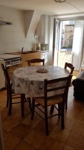una mesa y sillas en una cocina con mesa, mesa y mesa en La mémée du Saillant, en Voutezac