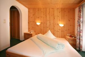 - une chambre avec un lit blanc et des murs en bois dans l'établissement Hotel Silbertal - Almhütten, à Sölden