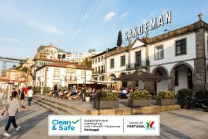 un groupe de personnes marchant dans une rue avec des bâtiments dans l'établissement The House of Sandeman - Hostel & Suites, à Vila Nova de Gaia